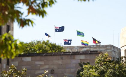The rainbow flag flies alongside the Australian and Aboriginal Flags on top of UQ's Forgan Smith building.